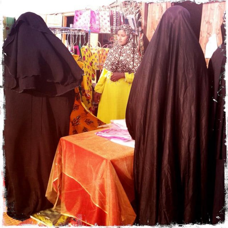 Day trip with friends to the Western Region and the Mazayin Dhafra Camel Festival, 220 kms west of Abu Dhabi on December 20, 2013.Local women peruse a booth selling ladies dresses.  Picture taken with the Hipstamatic app for the iPhone. Liz Claus / The National