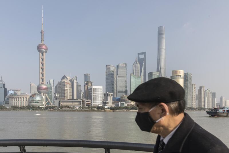 A pedestrian wearing a protective mask walks on the Bund waterfront in Shanghai, China, on Thursday, Jan. 30, 2020. The coronavirus death toll rose to 170 and confirmed cases in China soared past 7,700, as the outbreak spread to India and the Philippines for the first time. Photographer: Qilai Shen/Bloomberg