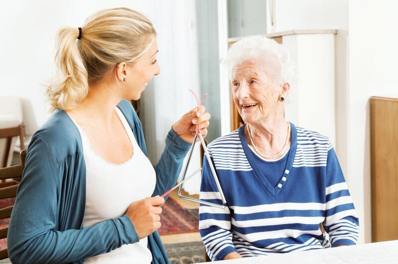 young therapist playing a triangle to senior woman, music therapy , useful especially for people with Alzheimer disease