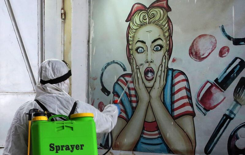 A volunteer disinfects a shop in Baghdad's Bayaa neighbourhood.   AFP