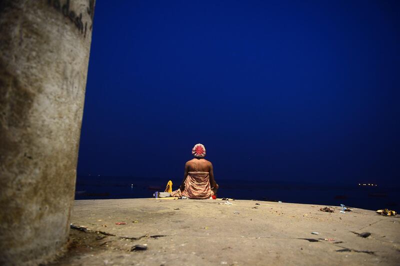 An Indian devotee performs evening prayers at Dashasamedh Ghat on the banks of the holy river Ganges in Varanasi. AFP