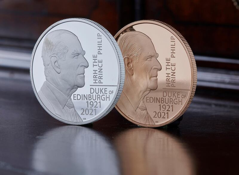 This undated photo issued by HM Treasury shows the silver and gold coins commemorating the life of Prince Philip, the Duke of Edinburgh, unveiled by Chancellor Rishi Sunak on Saturday June 26, 2021. The special edition 5 pound coin features an original portrait of the Duke and the coin's design was approved by the Duke before his death. (HM Treasury via AP)