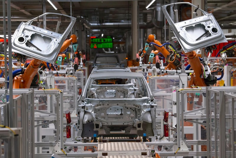 FILE- In this Tuesday, Feb. 25, 2020 file photo, robots work on an electric car ID.3 body at the assembly line during a press tour at the plant of the German manufacturer Volkswagen AG (VW) in Zwickau, Germany. Volkswagen plans six large battery factories in Europe by 2030 so it sell more electric cars while driving down battery prices and making electric mobility more affordable, an effort that would reduce dependence on Asian suppliers and help the company compete with newcomer Tesla. (AP Photo/Jens Meyer, file)