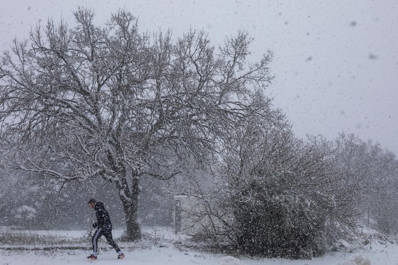 A man walks in the snow near the Quneitra border crossing between Syria and the Israeli-controlled Golan Heights. AP