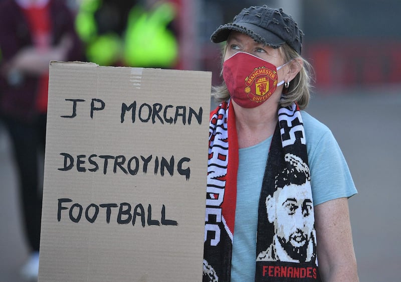 A supporter holding a placard reading "JP Morgan Destroying Football"  attends a protest against Manchester United's owners. AFP