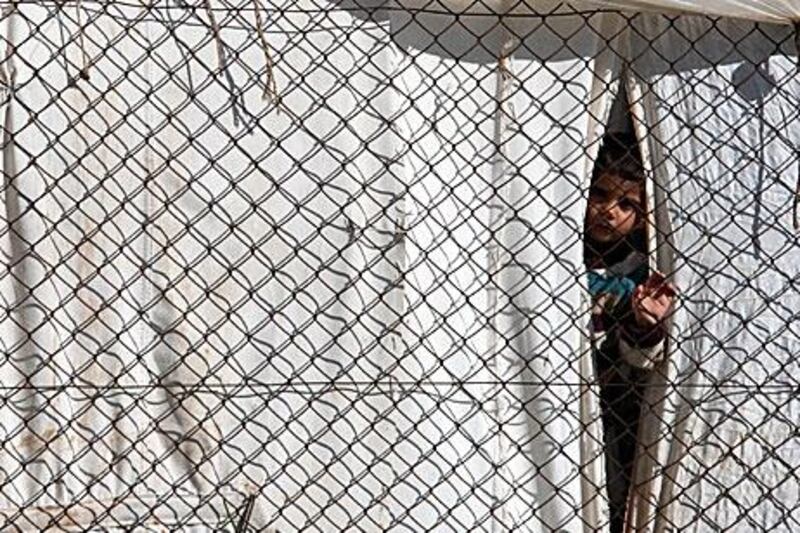 A boy peers out of a tent in a camp for Syrian refugees in the Turkish city of Antakya yesterday.