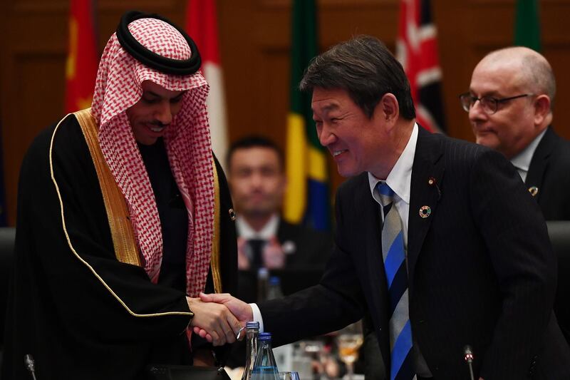 Japan's Foreign Minister Toshimitsu Motegi (R) shakes hands with Saudi Foreign Minister Prince Faisal bin Farhan to mark the handover to the Saudis as future hosts, at the end of the third plenary session of the G20 foreign ministers' meeting in Nagoya, Aichi prefecture on November 23, 2019. / AFP / CHARLY TRIBALLEAU
