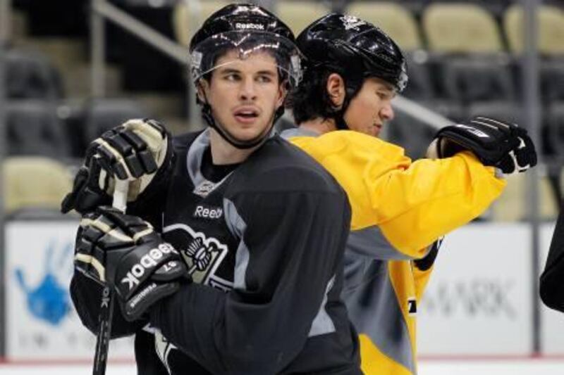 Pittsburgh Penguins' Sidney Crosby, left,  stands behind Arron Asham as he participates in practice with teammates on Thursday, Nov. 10, 2011 in Pittsburgh. Coach Dan Bylsma said Thursday afternoon Crosby will not play Friday or Saturday and that his status remains uncertain. Crosby hasn't played since being diagnosed with concussion-like symptoms in early January.  (AP Photo/Keith Srakocic)