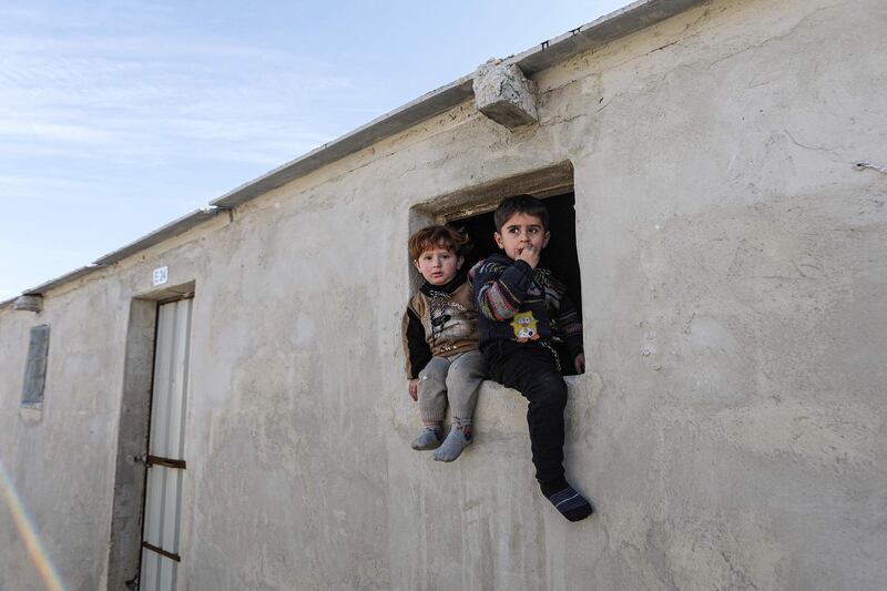 Children sit in a window of a new housing unit at a newly-constructed cement camp for Syrians displaced by conflict in the village of Niyarah in the rebel-controlled northern countryside of Syria's Aleppo province. AFP