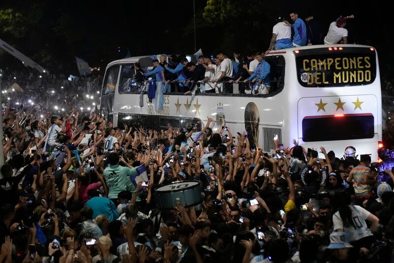 Argentina players on an open-top bus are greeted by fans after arriving home from the Qatar World Cup. AP