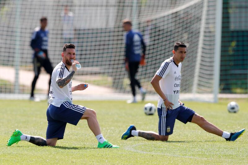 Lionel Messi, left, and Angel Di Maria stretch during training. Ricardo Mazalan / AP Photo