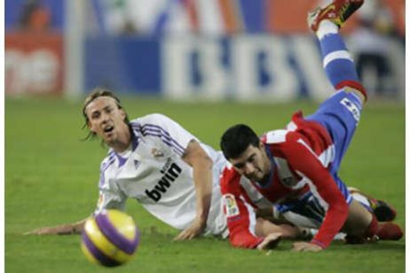 The Real Madrid midfielder Guti, left, and Atletico's Jose Antonio Reyes tangle for the ball.