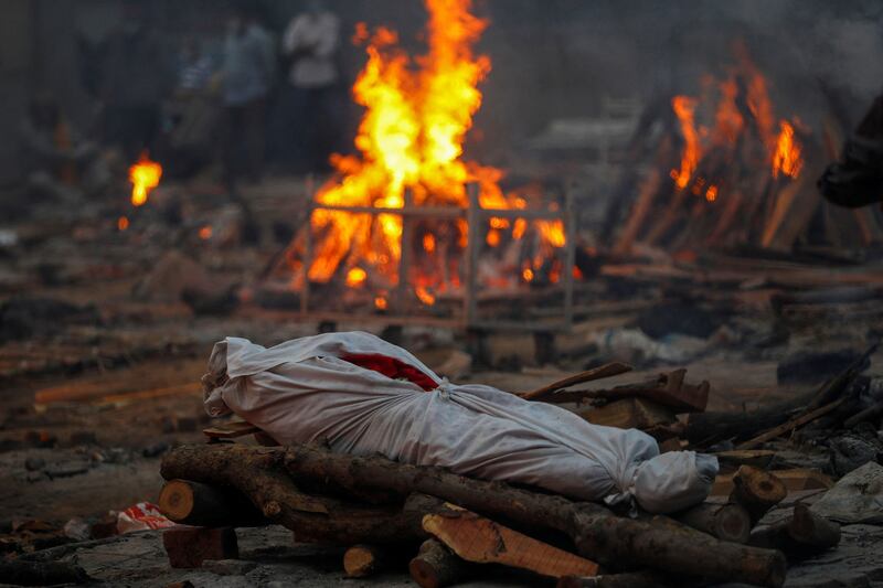 The body of a person who died from the coronavirus disease lies on a funeral pyre during a mass cremation at a crematorium in New Delhi, India on May 1, 2021. By Adnan Abidi, Pulitzer Prize Winner for Feature Photography. Reuters
