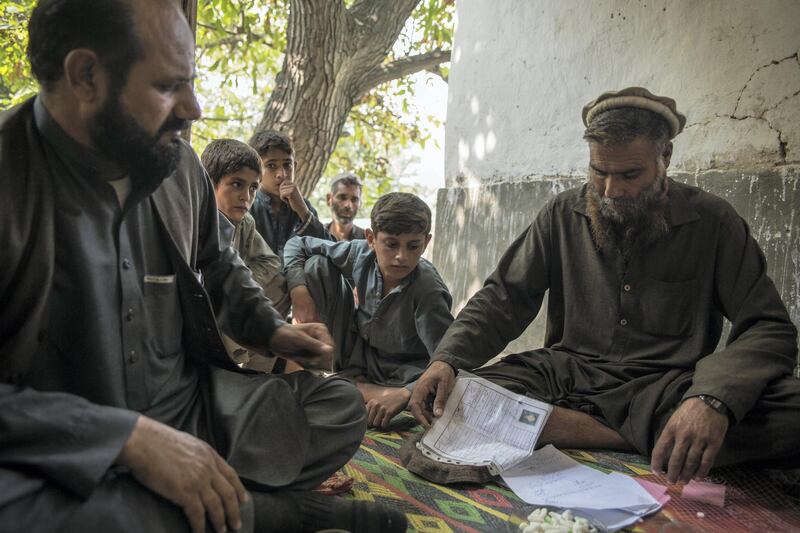 Rahat Gul, 45, who lost his son Khyber in a US drone strike in rural Nangarhar, sits in is home with his grandchildren and neighbours, showing off the ID registration cards of those who had died. "They weren't terrorists and they were martyred innocetly" he says. "How can we receive justice?"
