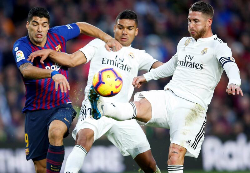 Real Madrid's Casemiro (C) and Sergio Ramos (R) in action against FC Barcelona's Luis Suarez (L) during a Spanish La Liga soccer match between FC Barcelona and Real Madrid at the Camp Nou stadium in Barcelona, northeastern Spain. EPA