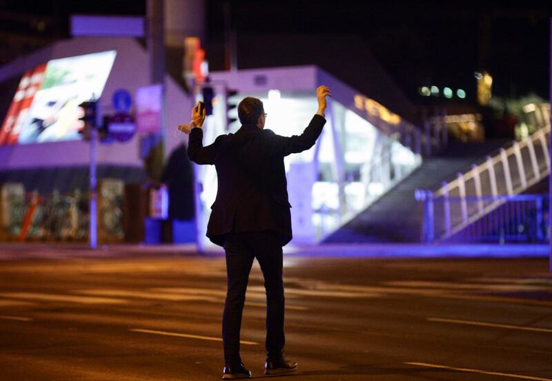 A man holds his hands up as police officers check him on a street after exchanges of gunfire in Vienna. Reuters