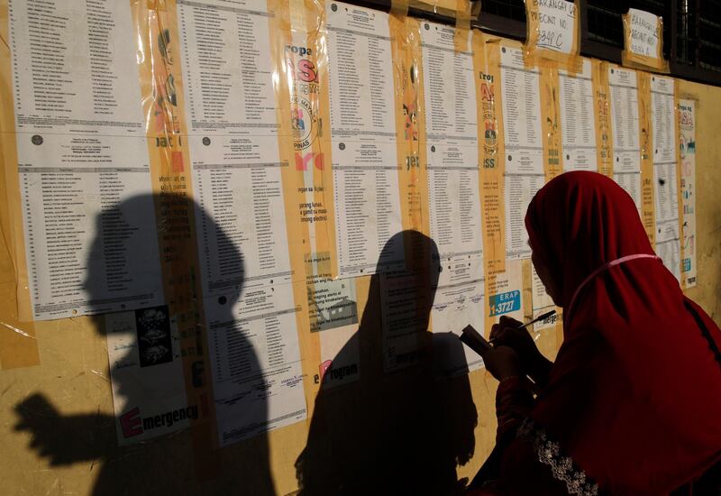 Filipinos look for their names and corresponding voting precincts on a board at a school in Manila, Philippines.   EPA