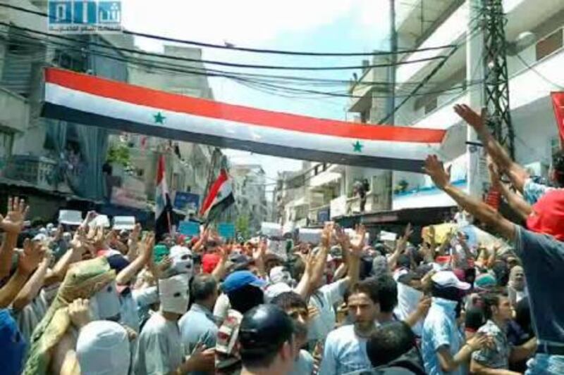 epa02859729 A grab made on 08 August 2011 from a handout video made available by Shaam News Network on its youtube channel, shows Syrians waving a national flag in Latakia, Syria. According to media reports, two women and two children were shot dead by security forces on 08 August as troops intensified their operations in the eastern Syrian city of Deir al-Zour for the second day. Activists also said that some 1,500 people had been arrested in the central city of Hama.  EPA/SHAAM NEW NETWORK/HANDOUT BEST QUALITY AVAILABLE/EPA IS USING AN IMAGE FORM AN ALTERNATIVE SOURCE, THEREFORE EPA COULD NOT CONFIRM THE EXACT DATE AND SOURCE OF THE IMAGE. HANDOUT EDITORIAL USE ONLY/NO SALES *** Local Caption ***  02859729.jpg