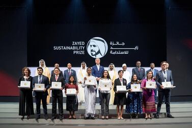 Sheikh Mohammed bin Rashid, Vice President and Ruler of Dubai, Sheikh Mohamed bin Zayed, Crown Prince of Abu Dhabi and Deputy Supreme Commander of the Armed Forces, and Dr Sultan Al Jaber, Minister of State, chairman of Masdar and chief executive of Adnoc Group, stand for a photograph with this year's winners of the Zayed Sustainability Award. Mohammed Al Hammadi / Ministry of Presidential Affairs 