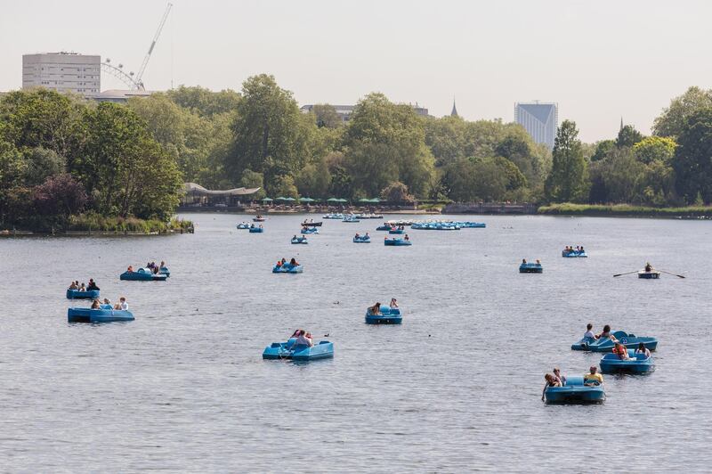 People in paddle boats on the lake during sunny weather in Hyde Park in London. EPA