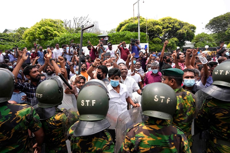Sri Lankan government supporters cheer outside the prime minister's residence in Colombo. AP