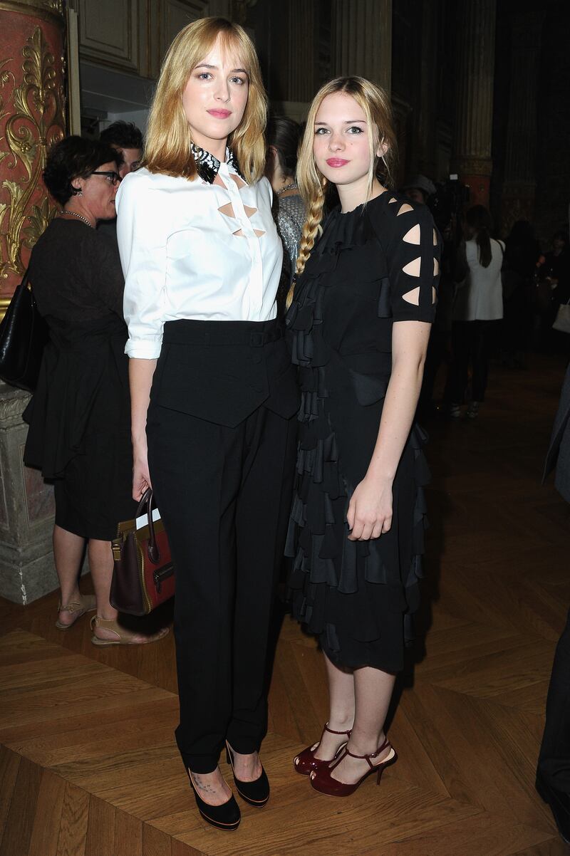Dakota Johnson, in a blouse and tailored trousers, and Stella Banderas attend the Viktor & Rolf show as part of Paris Fashion Week at La Gaite Lyrique on July 3, 2013 in Paris, France. Getty Images