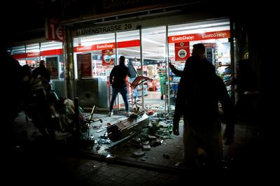 People stand in front of a shop that was plundered during riots on early June 21, 2020 in Stuttgart, southern Germany. Hundreds of people ran riot in Germany's Stuttgart city centre in the early hours of Sunday, June 21, 2020, throwing stones and bottles at police and plundering stores after smashing shop windows. - Germany OUT
 / AFP / dpa / Julian RETTIG
