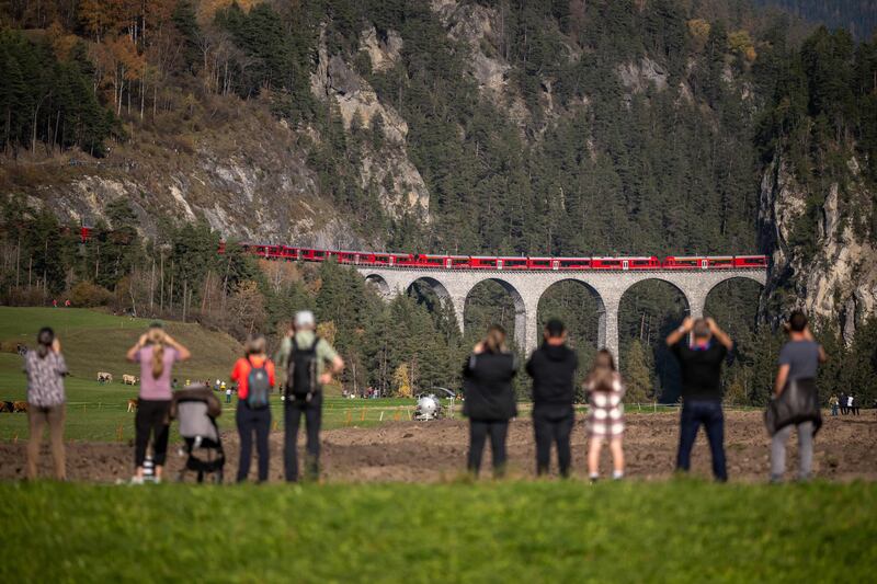 The enormous train crosses a viaduct.