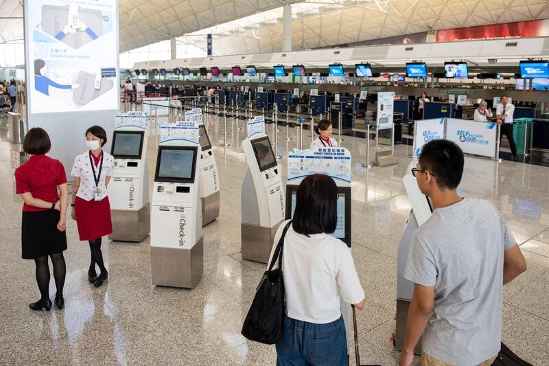 Passengers line up at check-in counters at Hong International Airport.  EPA