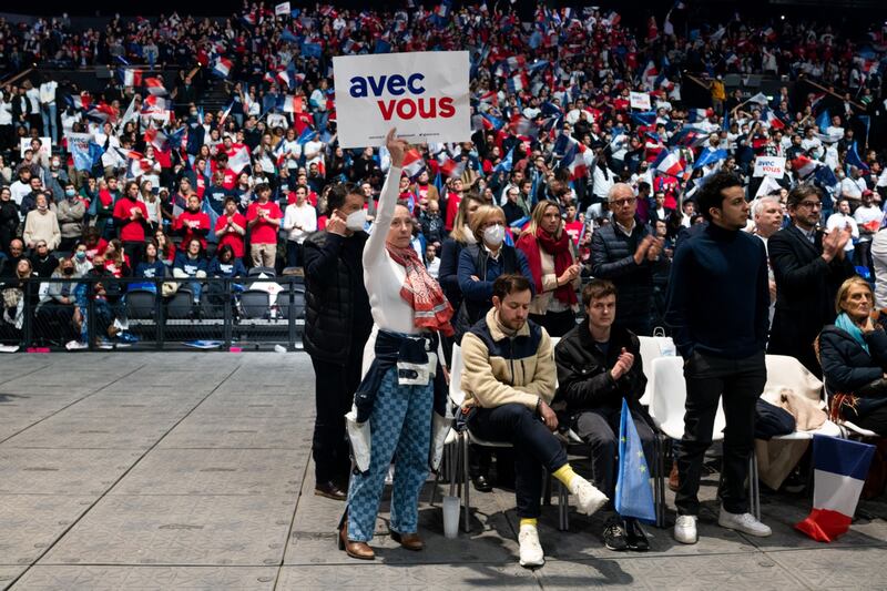 A supporter holds up a placard reading "With You" at an election campaign event for Emmanuel Macron in Paris. Bloomberg