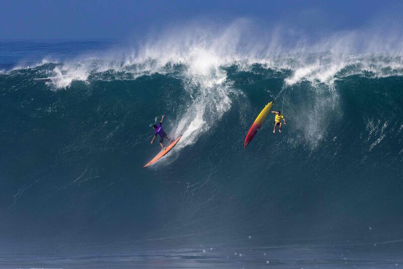 US surfer Eli Olsen rides a wave as Hawaiian surfer Jake Maki gets wiped out during The Eddie Aikau Big Wave Invitational surfing contest at Waimea Bay on the North Shore of Oahu in Hawaii. AFP