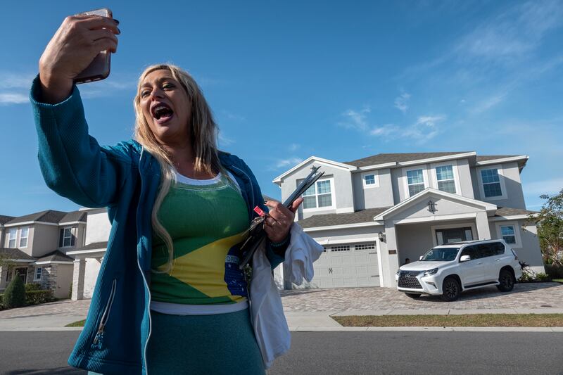 A Brazilian poses for a photo outside the house where Mr Bolsonaro is reportedly staying in Reunion, Florida. EPA