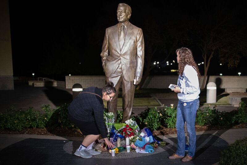 Mourners place candles at the foot of the statue at the George Bush Presidential Library in College Station, Texas. AFP