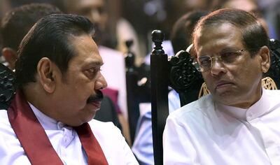 Sri Lanka’s President Maithripala Sirisena (R) listens to former president and currently appointed Prime Minister Mahinda Rajapakse attend a ceremony granting employment to social service workers, in Colombo on November 30, 2018.  Rajapakse was controversially named prime minister last month, but the parliament has in two votes toppled him in no-confidence motions which he and Sirisena are refusing to accept causing a deepening political crisis. / AFP / ISHARA S.  KODIKARA

