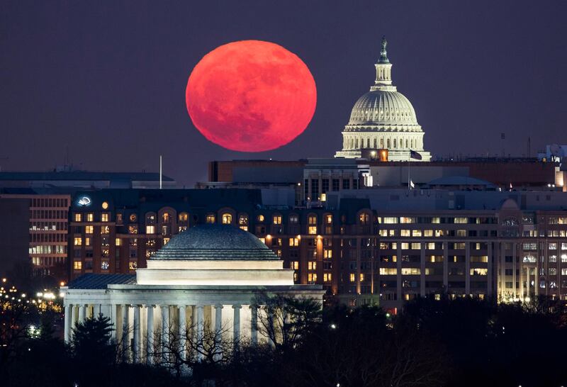 The 'supermoon' rises behind the US Capitol, right, and the Jefferson Memorial, bottom, in Washington, DC. Jim Lo Scalzo / EPA