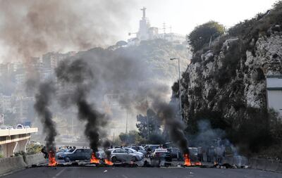 TOPSHOT - Lebanese protesters set tyres on fire to block a main tunnel on the highway between Beirut and the port city of Junieh at the Nahr el Kalb area in Dbayeh, north of Lebanon's capital on November 13, 2019. The previous night, street protests erupted across Lebanon after President Michel Aoun defended the role of his allies, the Shiite movement Hezbollah, in Lebanon's government, cutting off several major roads in and around Beirut, the northern city of Tripoli and the eastern region of Bekaa. In his televised address, Aoun proposed a government that includes both technocrats and politicians. / AFP / ANWAR AMRO
