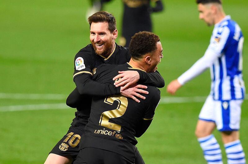 Barcelona's Barcelona's US defender Sergino Dest celebrates with Barcelona's Argentinian forward Lionel Messi (back) after scoring a goal during the Spanish League football match between Real Sociedad and Barcelona at the Anoeta stadium in San Sebastian on March 21, 2021. / AFP / ANDER GILLENEA
