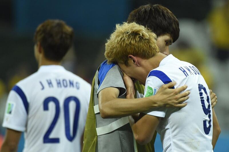 South Korea midfielder Son Heung-min, right, cannot hold back his tears following his team’s 1-0 loss to Belgium on Thursday. Odd Andersen / AFP

