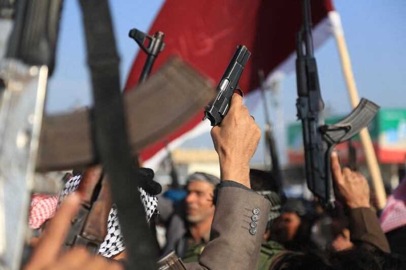 Armed clan members of Karbala clans lift their guns as they take to the streets in a show of force and to keep order amid a spate of anti-government protests, in the southern Iraqi city of Karbala. AFP