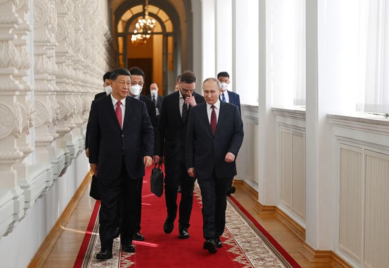 Mr Putin and Mr Xi walk through the Kremlin. Reuters