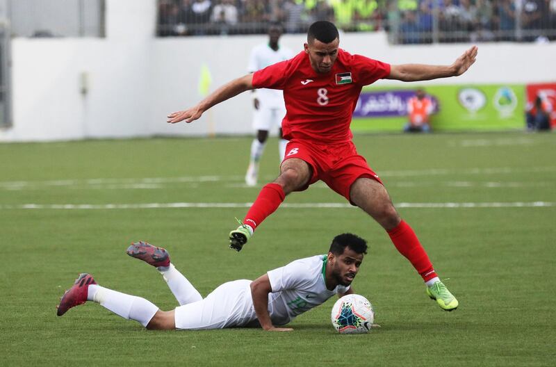 Palestine's Mohammed Yamen (top) vies for the ball with Saudi Arabias' Hatan Sultan during the Asian qualifiers soccer match for the FIFA 2022 World Cup between Palestine and Saudi Arabia at the Faisal Husseini Stadium, in the West Bank city of Ramallah.  EPA