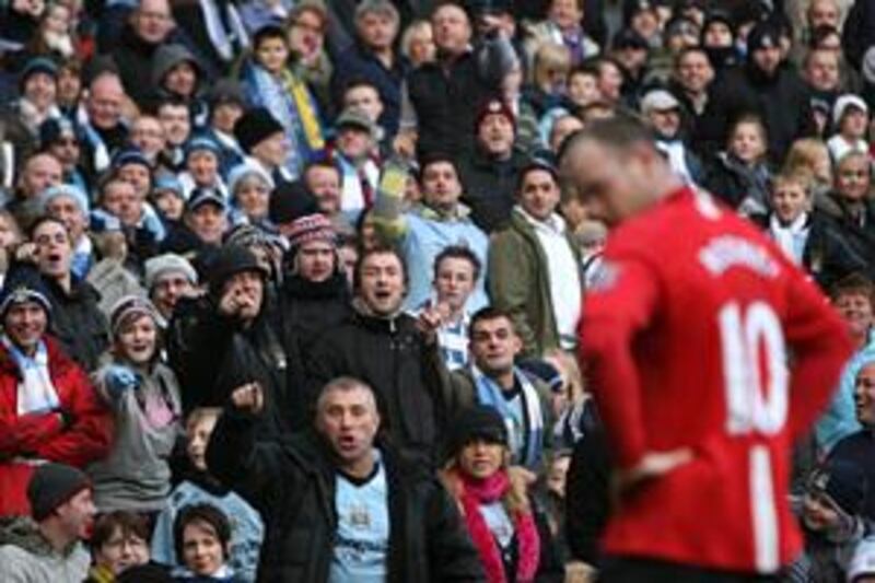 Manchester City fans taunt United striker Wayne Rooney during the derby at Eastlands last season. United won the game 1-0.