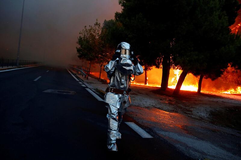 A firefighter wears a flame resistant uniform as wildfire burns in the town of Rafina, near Athens. Reuters