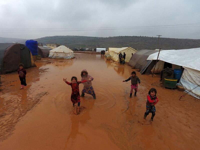 Children play near tents sheltering Syrians who fled ongoing battles in the Idlib province in a camp for displaced people at Sarmada near the border with Turkey. AFP