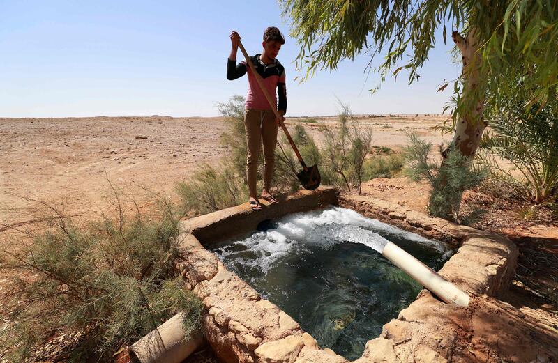 A farmer washes his shovel in a water tank in Al Sahl village. About 200 families live in the hamlet  and their only neighbour is one of the country's largest military bases.