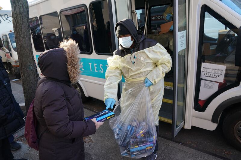 An official hands out Covid-19 testing kits in Bensonhurst, Brooklyn, in New York. The resumption of holiday travel and the emergence of Omicron has left Americans scrambling  to find Covid tests. AFP