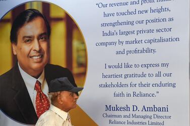 A shareholder walks past a poster of India's richest man and oil-to-telecom conglomerate Reliance Industries chairman Mukesh Ambani. Last week, Aramco’s inaugural earnings call covered preliminary plans to pay $15bn for 20 per cent of Reliance Industries’ refining and petrochemicals business. AFP