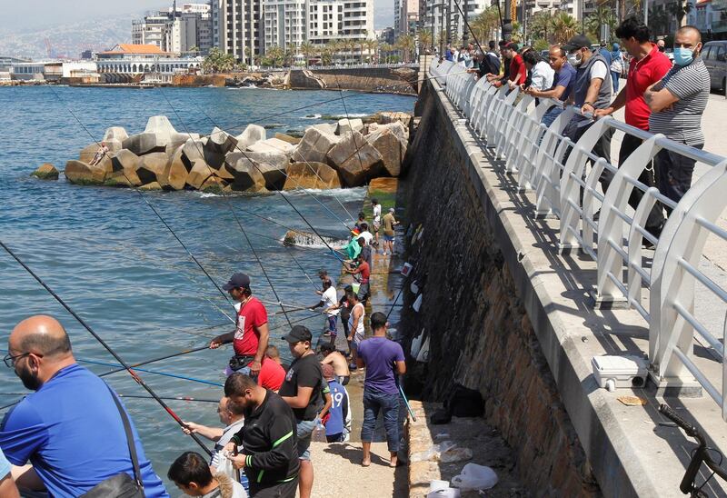 Fishermen dangle their lines to catch fish at Beirut's seaside Corniche, as Lebanese authorities warned of a new wave of the coronavirus. Reuters