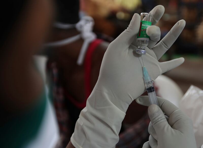 A health worker prepares a Covishield vaccine shot at a temple complex in Hyderabad, India.  AP
