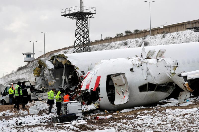 Pegasus Airlines technicians work at the wreckage of Pegasus Airlines Boeing 737-86J plane, after it overran the runway during landing and crashed, at Sabiha Gokcen airport, in Istanbul, Turkey. REUTERS